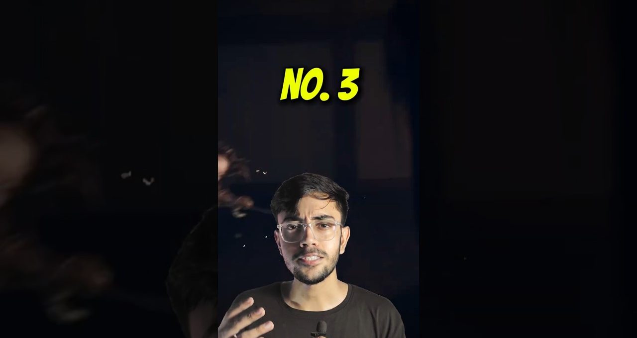 Young man wearing glasses speaking into a small microphone with "No. 3" text above