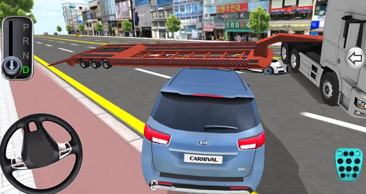 Blue Kia Carnival stopped behind a low car transporter trailer across city street.