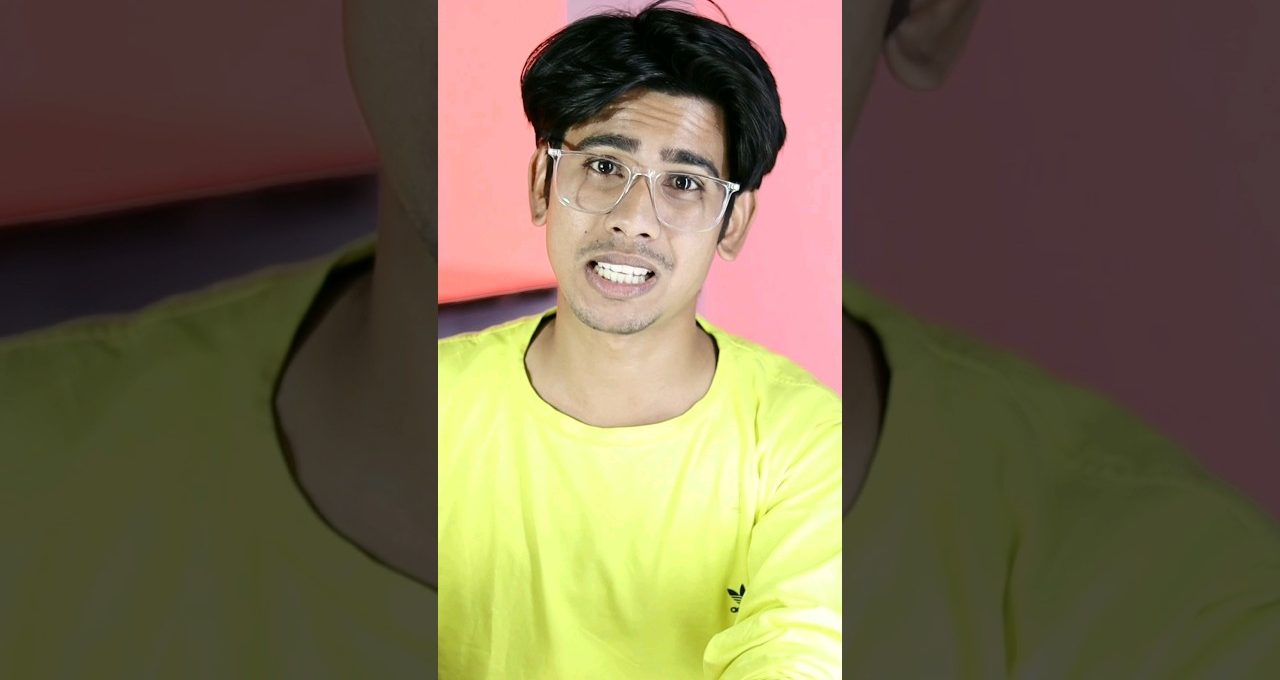 Young man wearing clear glasses and neon yellow shirt speaking against pink background