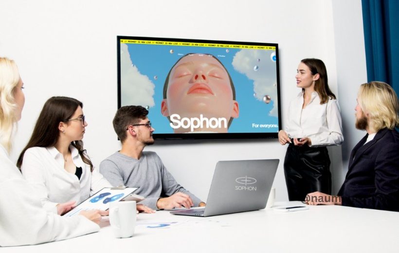 Team in a meeting room watching a presenter and a display showing "Sophon" artwork