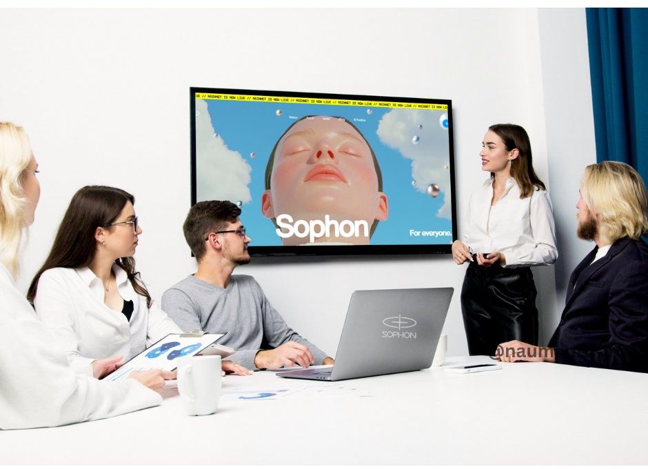 Team in a meeting room watching a presenter and a display showing "Sophon" artwork