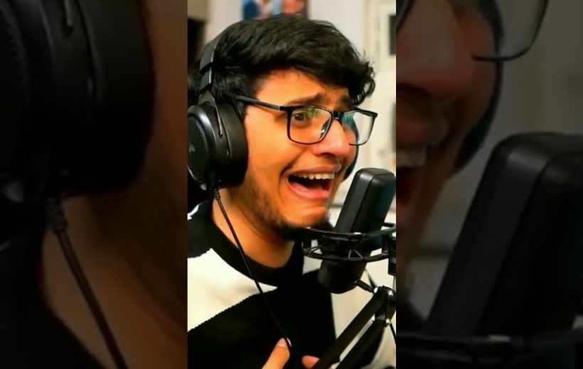 Young man wearing headphones passionately singing into a studio microphone with expressive face
