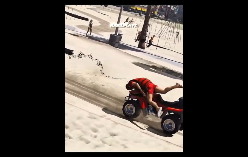 Person in red shirt falling off a red ATV skidding across sandy beach path