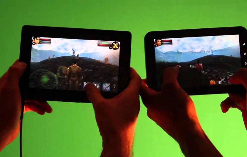 Two people holding tablets playing the same RPG game against a green background