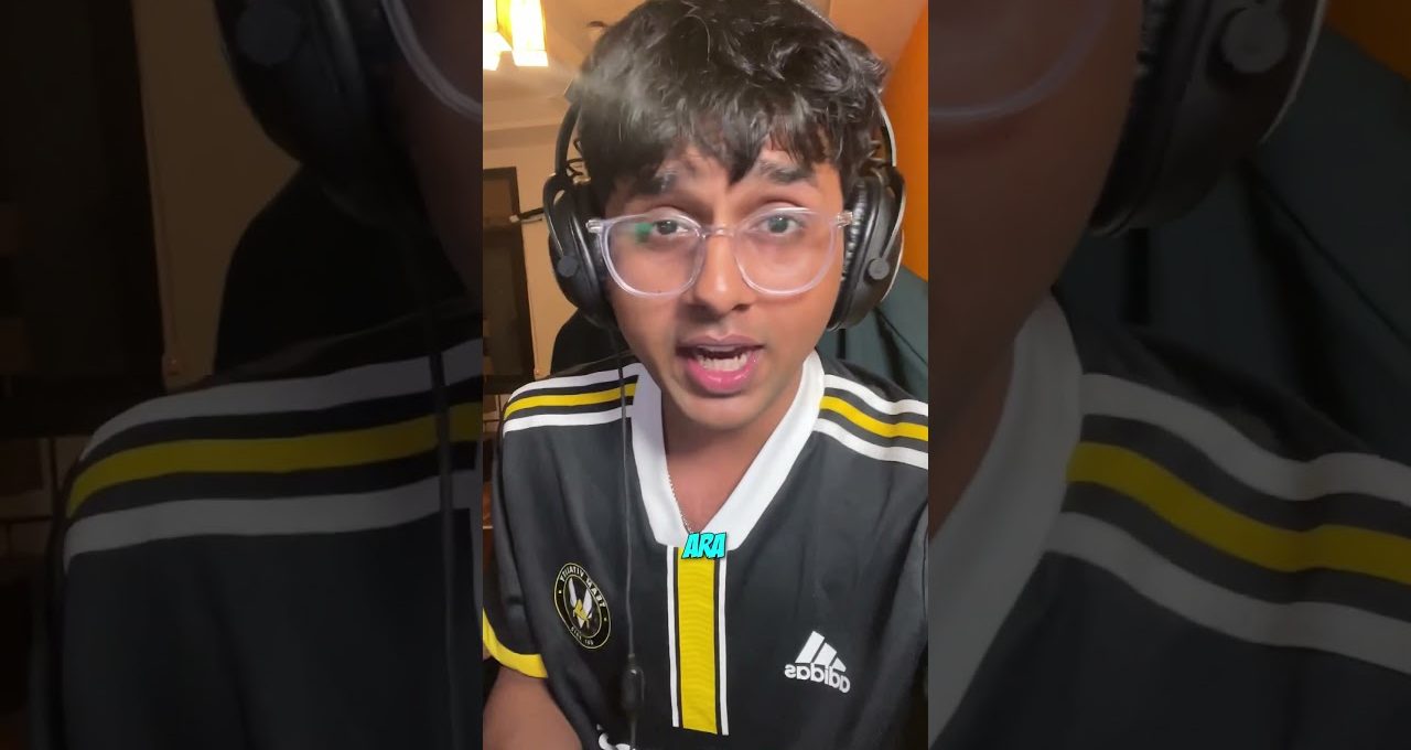 Young person wearing glasses and headphones speaking on camera in a bedroom.