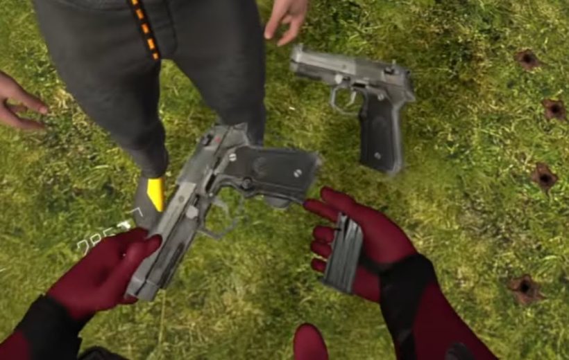 Person wearing red gloves reloads handgun magazine next to another pistol on grass