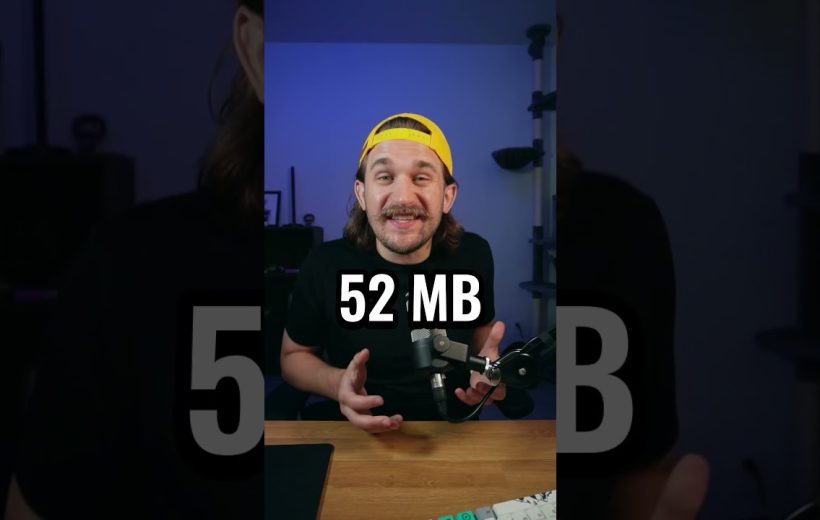 Man wearing yellow cap speaking into microphone at desk with "52 MB" text