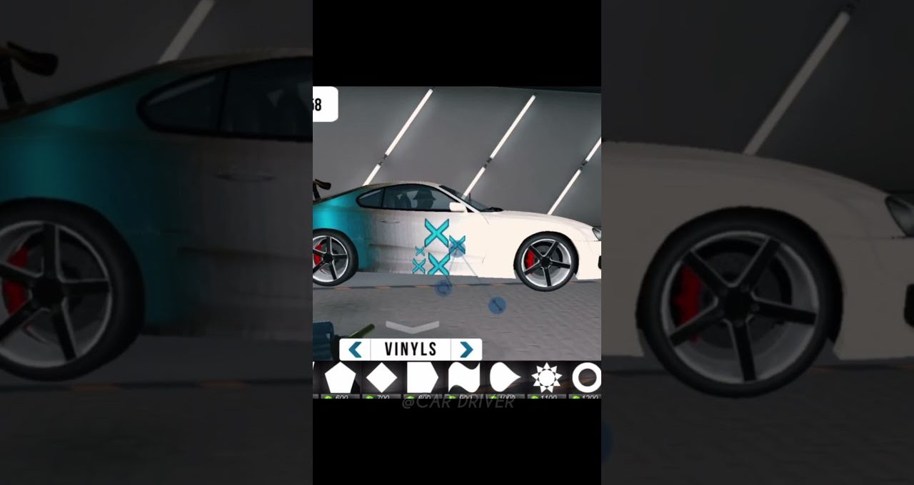 White sports car in a garage being customized with blue vinyl graphics and decals