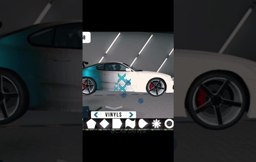 White sports car in a garage being customized with blue vinyl graphics and decals