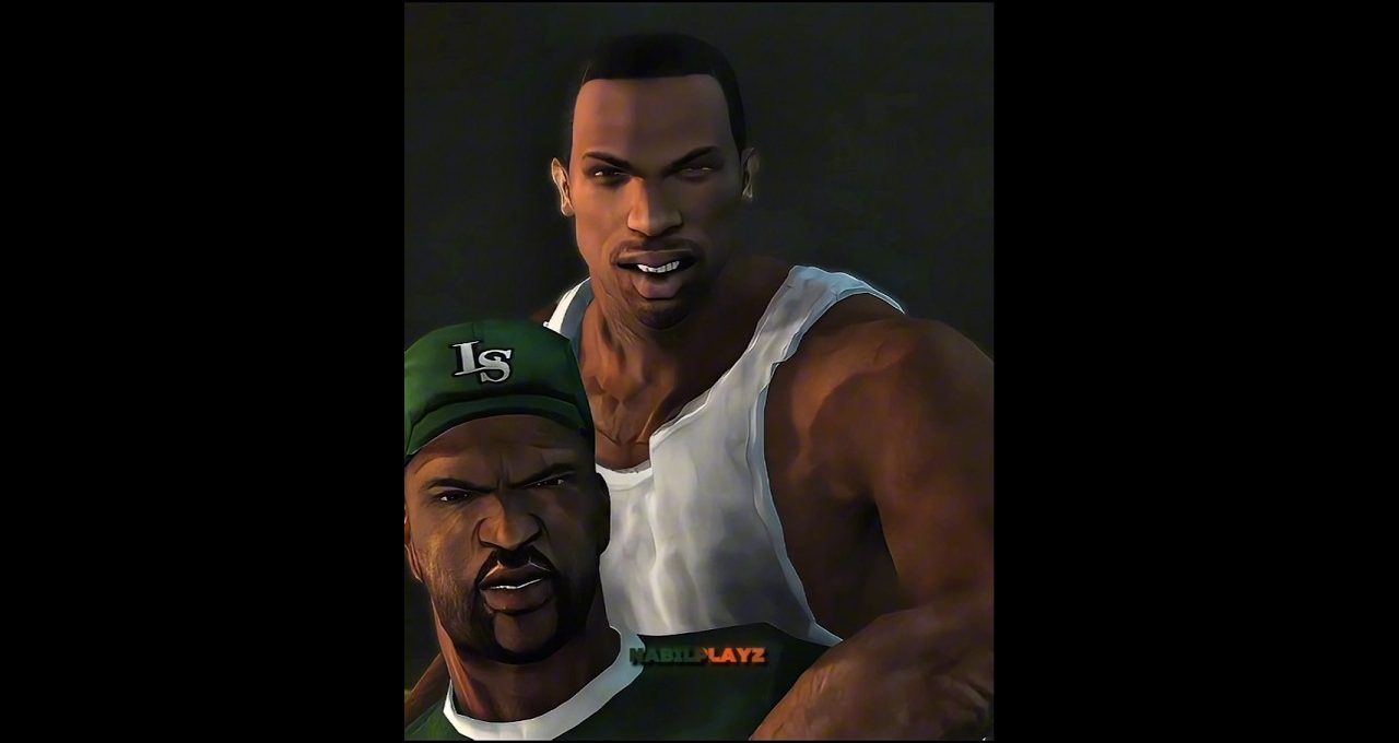 Two muscular men pose together, one in a white tank top and one wearing a green cap.