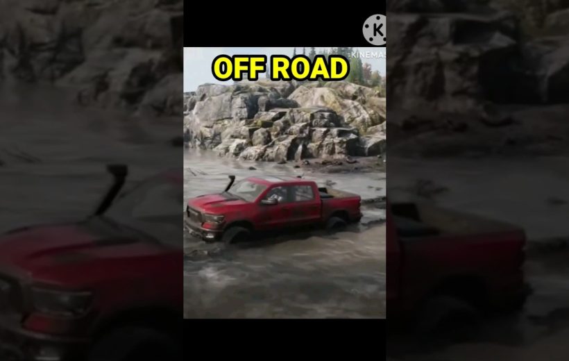 Red pickup truck driving through muddy off-road terrain with rocky cliffs in background