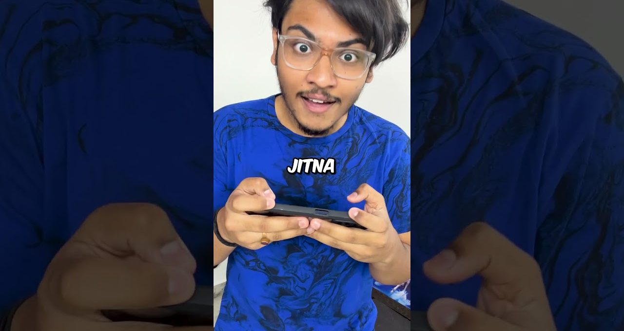 Young man with glasses intensely playing a handheld game on a smartphone