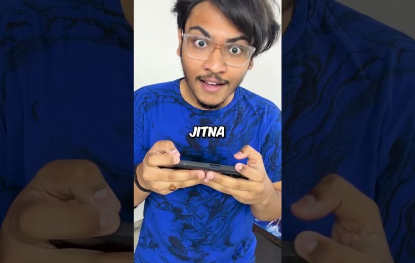 Young man with glasses intensely playing a handheld game on a smartphone