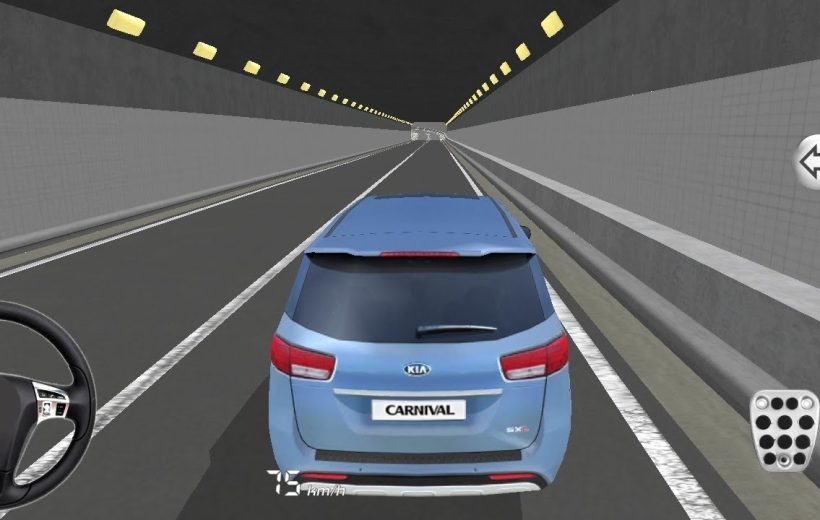 Blue Kia Carnival minivan driving inside a lit tunnel viewed from behind, dashboard visible