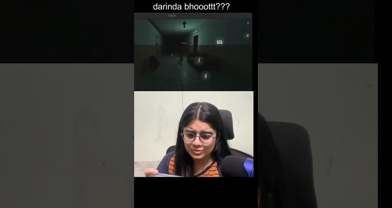Woman wearing glasses reacting with concern while watching a dark horror game clip.