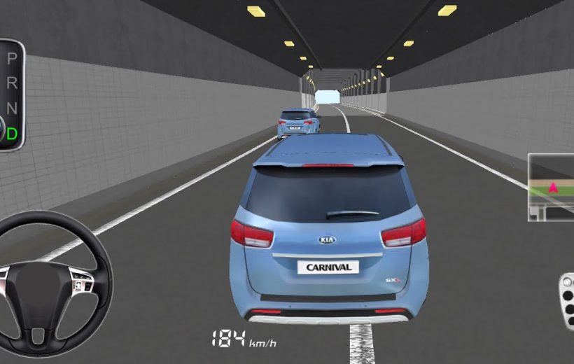 Blue Kia Carnival SUV driving behind another car through a lit road tunnel.