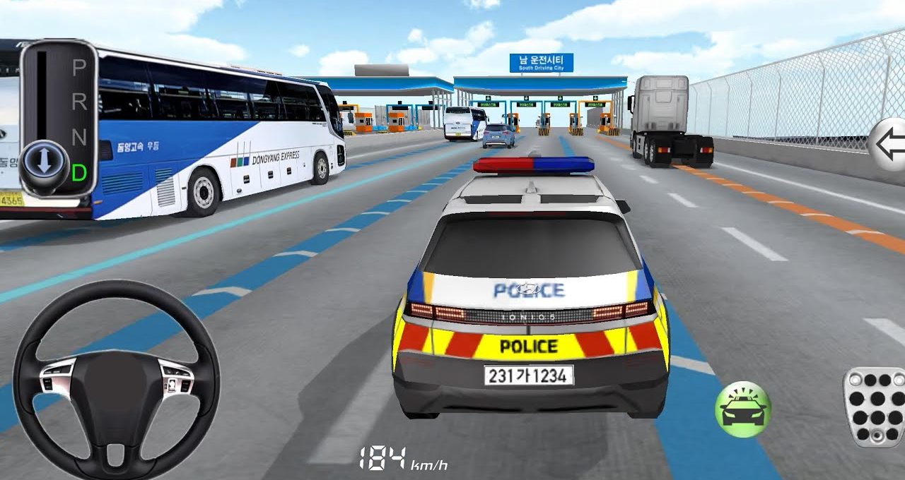 Rear view of a marked police car driving toward toll booths on a highway