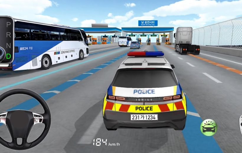 Rear view of a marked police car driving toward toll booths on a highway