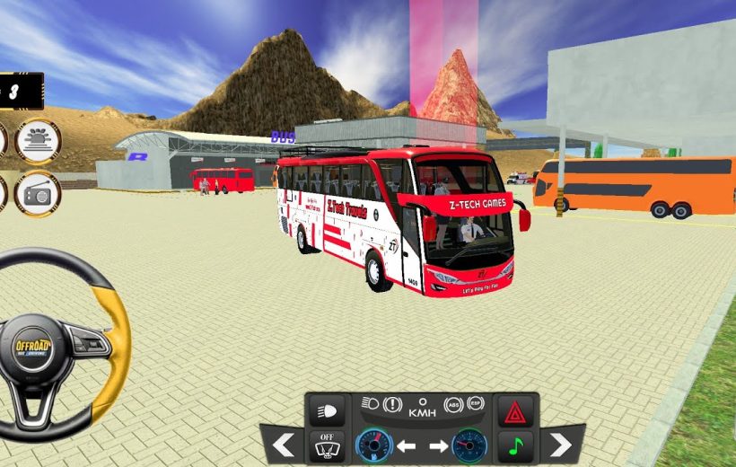 Red and white coach bus parked in a desert bus station with mountains behind