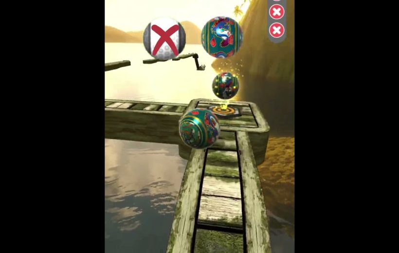 Colorful decorative ball rolling along a narrow wooden plank path over water