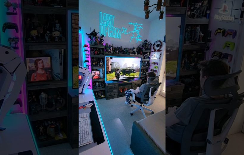 Person seated in gaming chair watching a large TV in RGB-lit gaming room