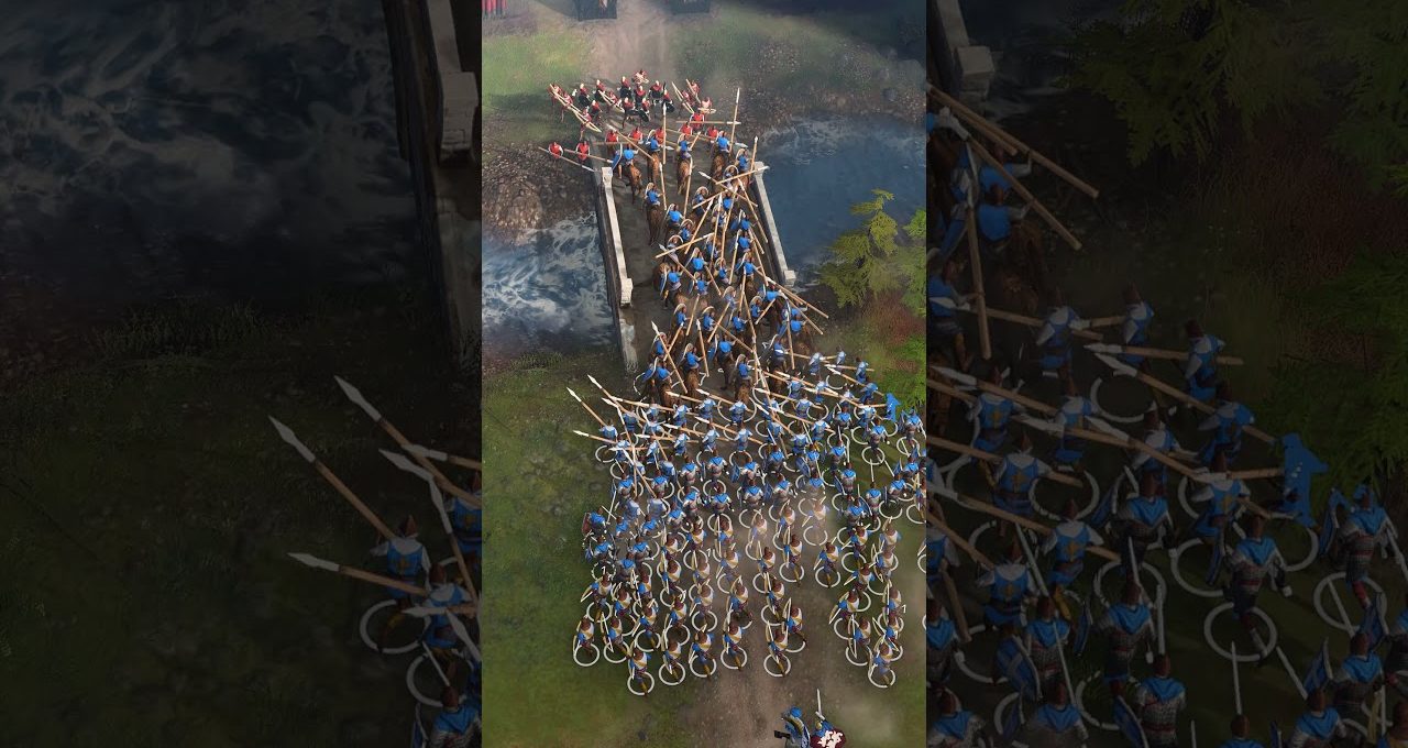 Large group of blue-clad medieval soldiers with spears crossing a narrow river bridge