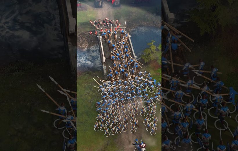 Large group of blue-clad medieval soldiers with spears crossing a narrow river bridge