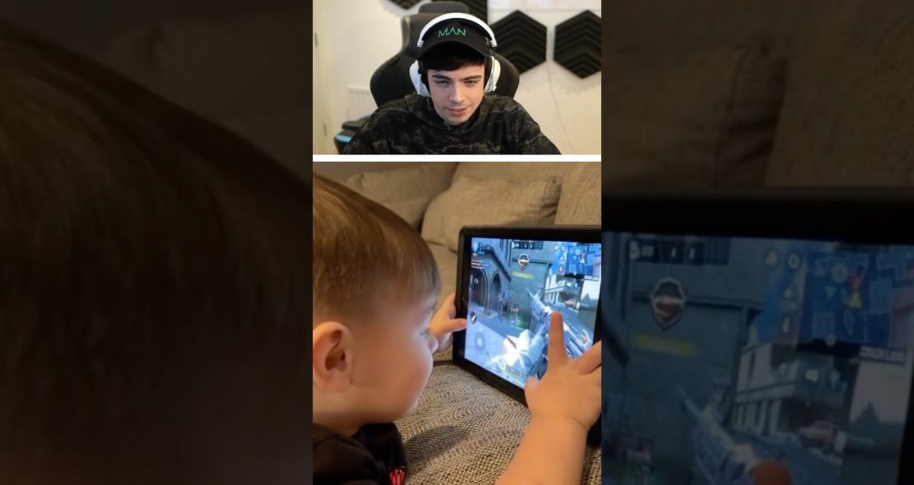 Young boy intensely playing a shooter game on tablet while streamer watches on screen