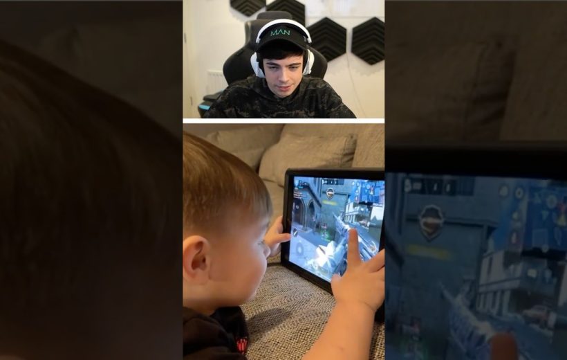 Young boy intensely playing a shooter game on tablet while streamer watches on screen