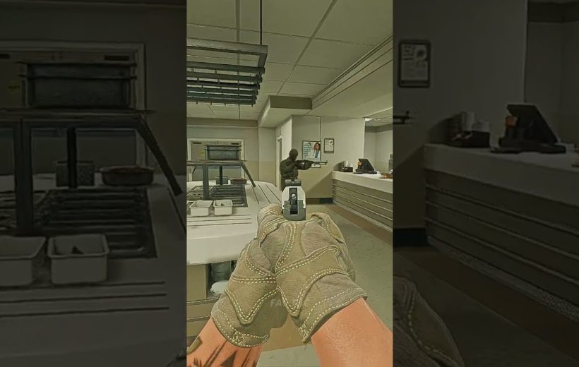 Player's gloved hands aiming a handgun down a cafeteria counter at armed guard
