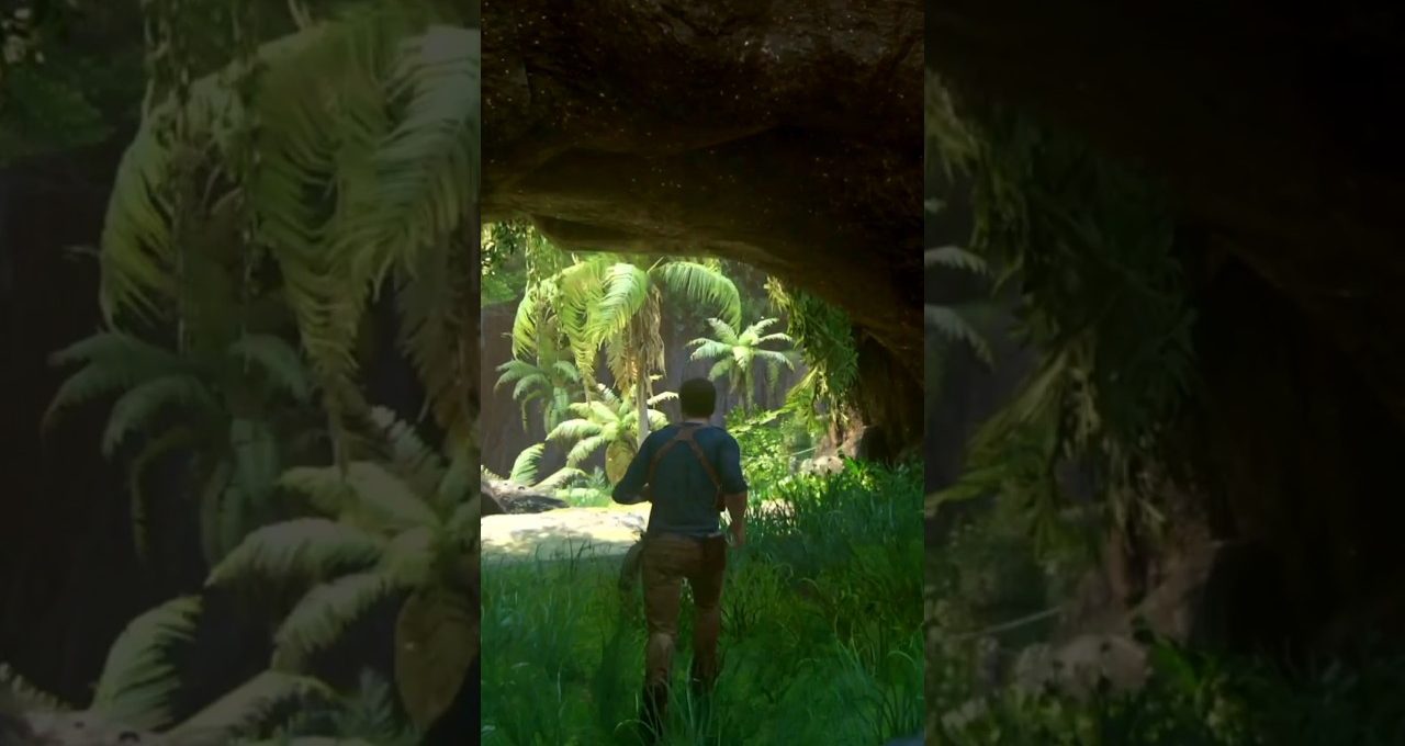 Man walking through shaded cave opening into lush tropical jungle with palm trees visible
