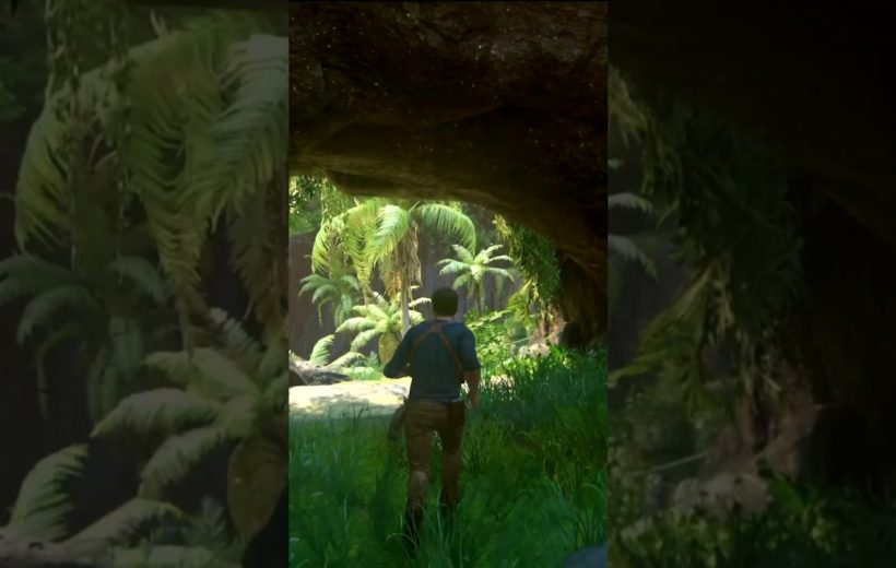 Man walking through shaded cave opening into lush tropical jungle with palm trees visible