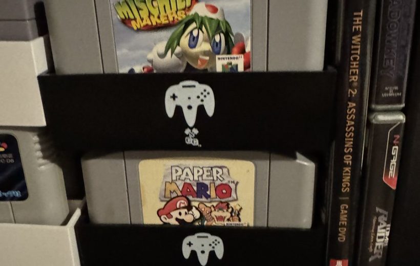 Stacked Nintendo 64 cartridges including Mischief Makers and Paper Mario in a shelf organizer