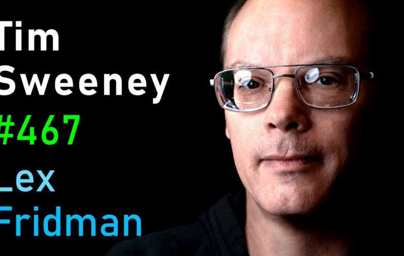 Close-up portrait of a man wearing glasses against black background with white and colored text