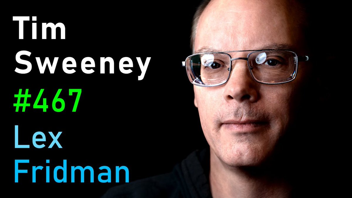 Close-up portrait of a man wearing glasses against black background with white and colored text