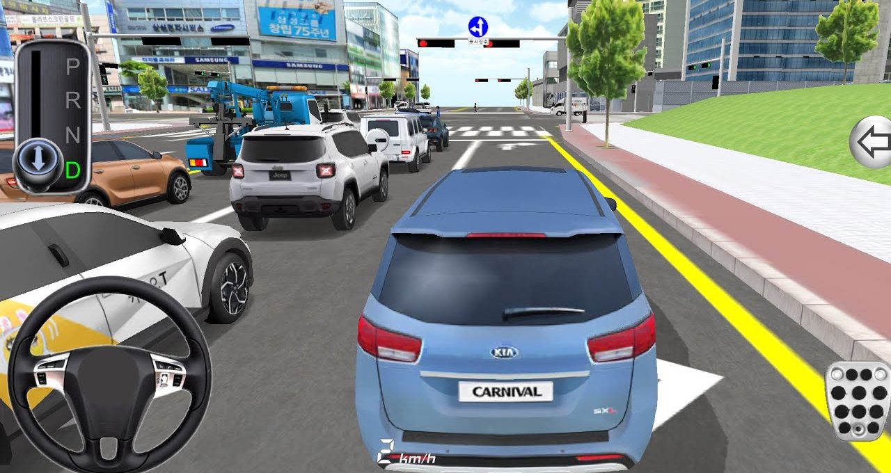 Blue Kia Carnival minivan driving in traffic toward an urban intersection with buildings