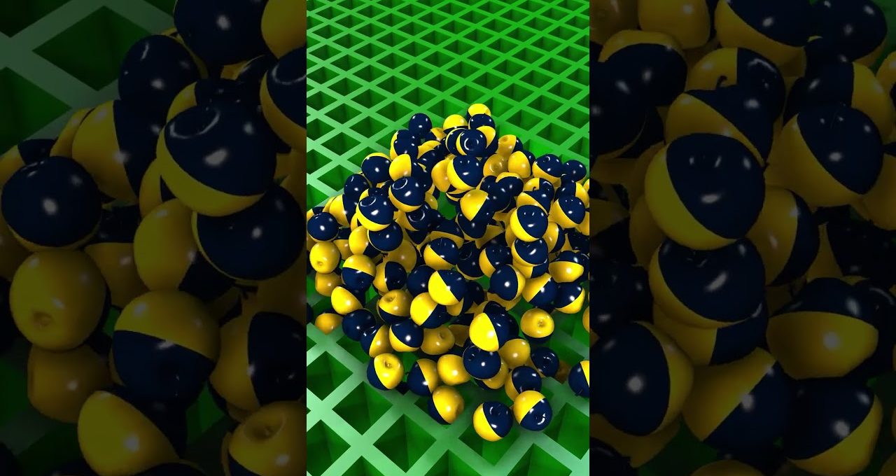 Pile of glossy navy and yellow half-striped spheres on a green lattice surface