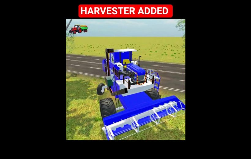 Blue combine harvester parked by roadside in a grassy field under clear sky