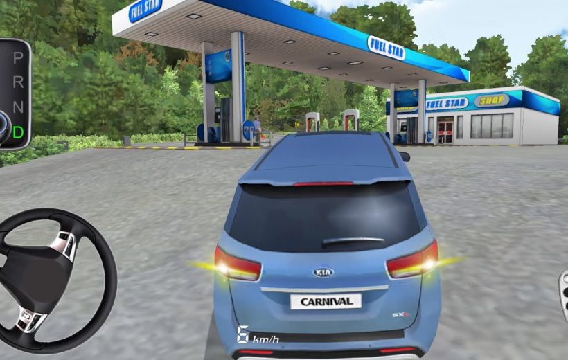 Blue Kia Carnival parked approaching a fuel station canopy with shop in background
