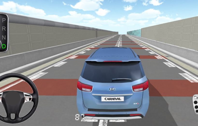 Rear view of a blue Kia Carnival on an empty simulated driving track