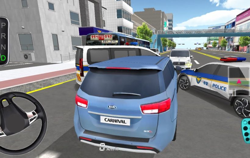 Blue Kia Carnival minivan stopped amid traffic with police car and city buildings visible