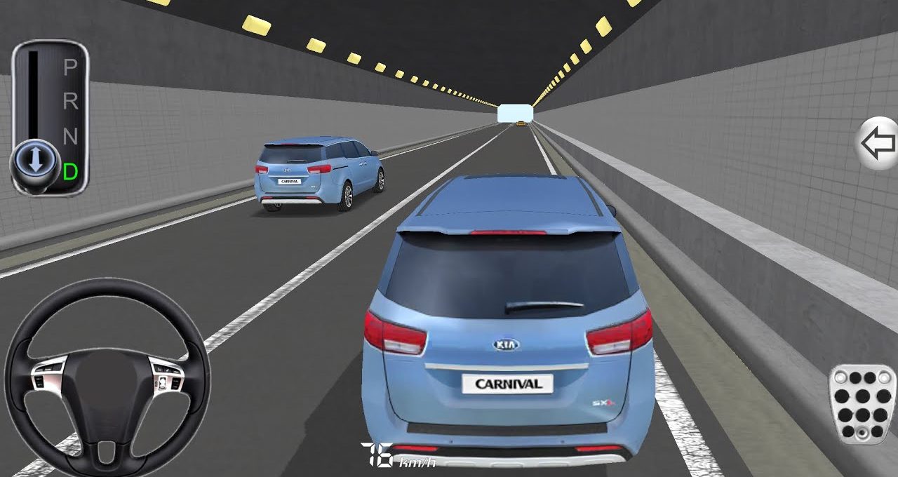 Rear view of a blue Kia Carnival driving through a lit highway tunnel interior