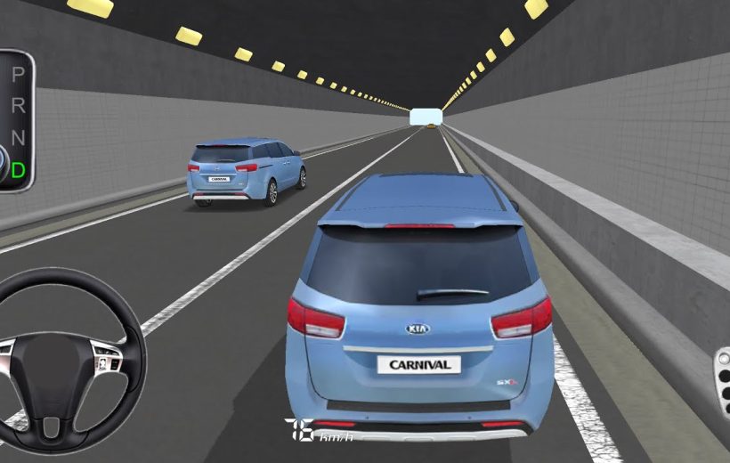 Rear view of a blue Kia Carnival driving through a lit highway tunnel interior