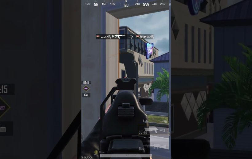 First-person shooter view aiming down iron sights toward a distant building entrance.