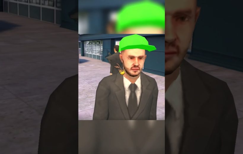 Man in a suit wearing a bright green baseball cap standing outdoors by buildings