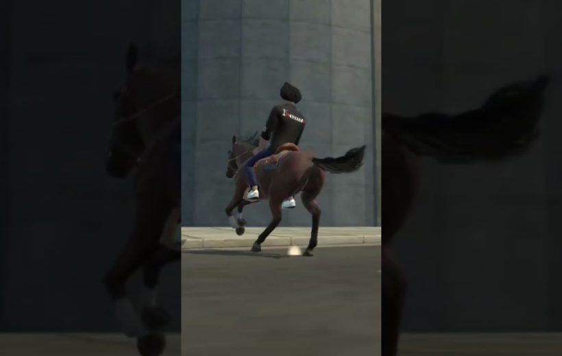 Person wearing jacket riding a brown horse at speed on a city street