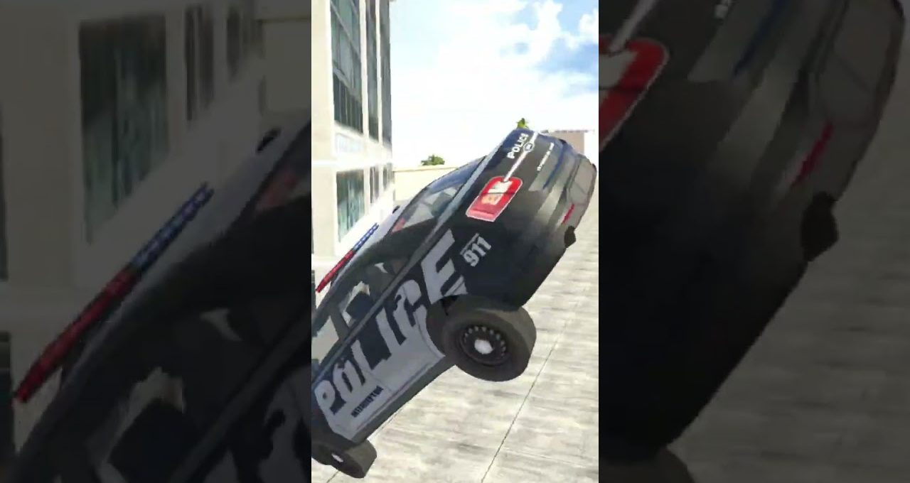 Police cruiser midair beside a building, tilted with wheels off the ground