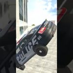 Police cruiser midair beside a building, tilted with wheels off the ground