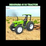 Bright green Indofarm 4110 tractor with driver pulling a disc harrow across dry field