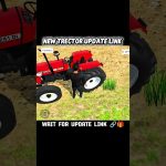 Person standing beside a red tractor on dirt ground with sparse grass patches